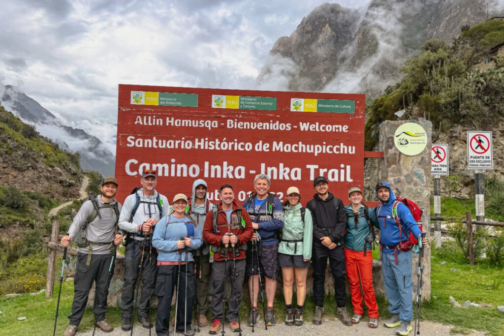 Group of hikers in front of sign for Inca Trail, Peru