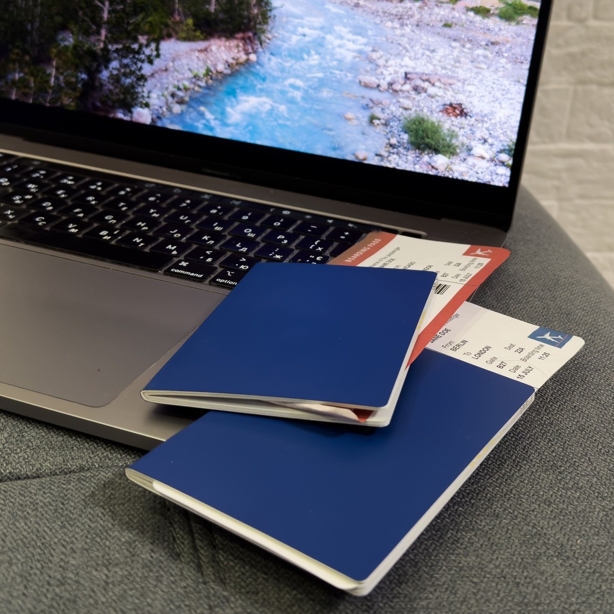 U.S. Passports With Boarding Tickets Inside Placed On Top Of An Open-Laptop Computer