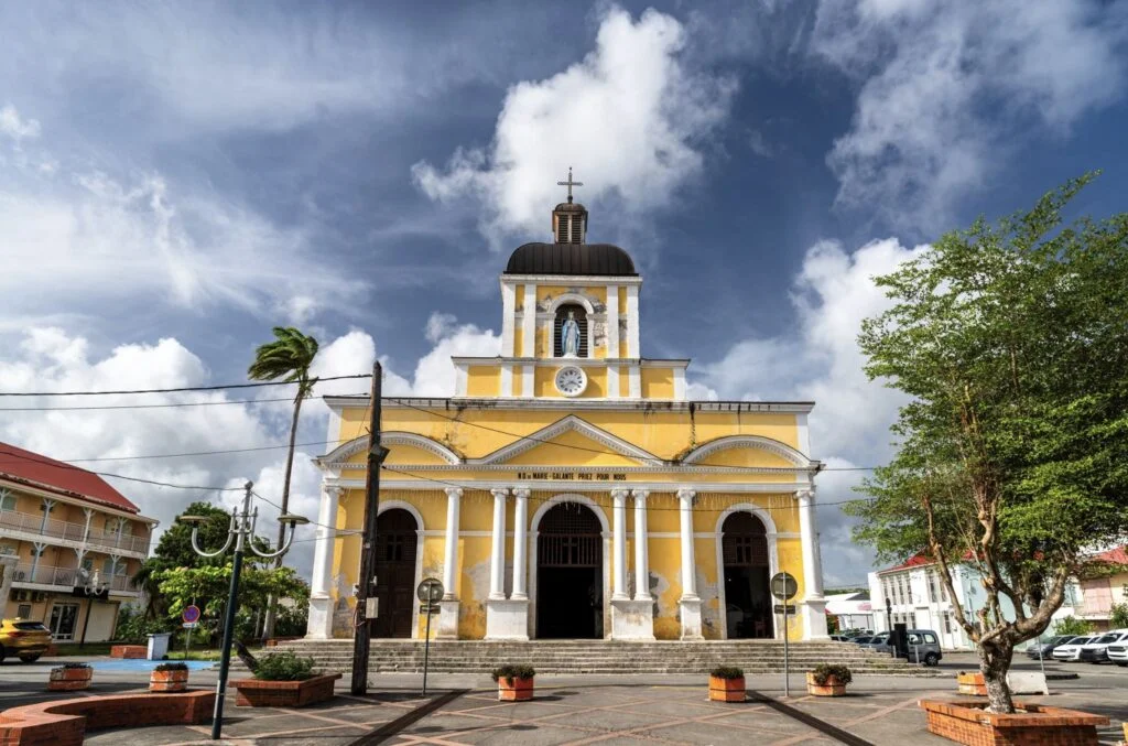 Facade of the Notre-Dame-de-l'Assomption-church under a cloudy sky in Grand-Bourg, Marie-Galante Island, Guadeloupe