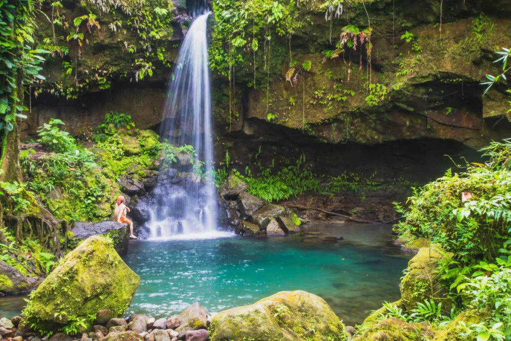 A swimmer enjoying Emerald Pool in the lush rain forest, the waterfall is a beautiful jewel of Dominica in the Caribbean