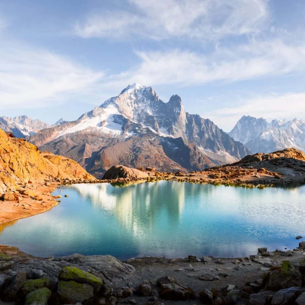 Crystal-clear Lac Blanc reflects sky and Mont Blanc range in French Alps near Chamonix. Peaceful alpine lake view with stunning mountain mirror and serene landscape