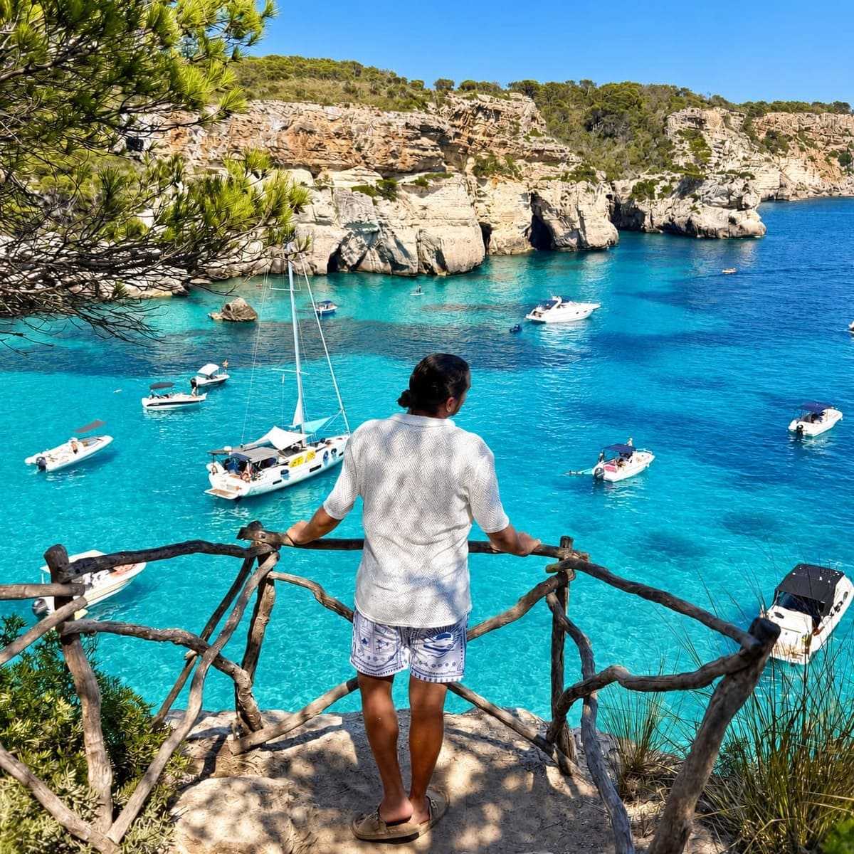 Male Tourist Admiring A View Of The Turquoise Mediterranean Sea In Menorca, Balearic Islands, Spain
